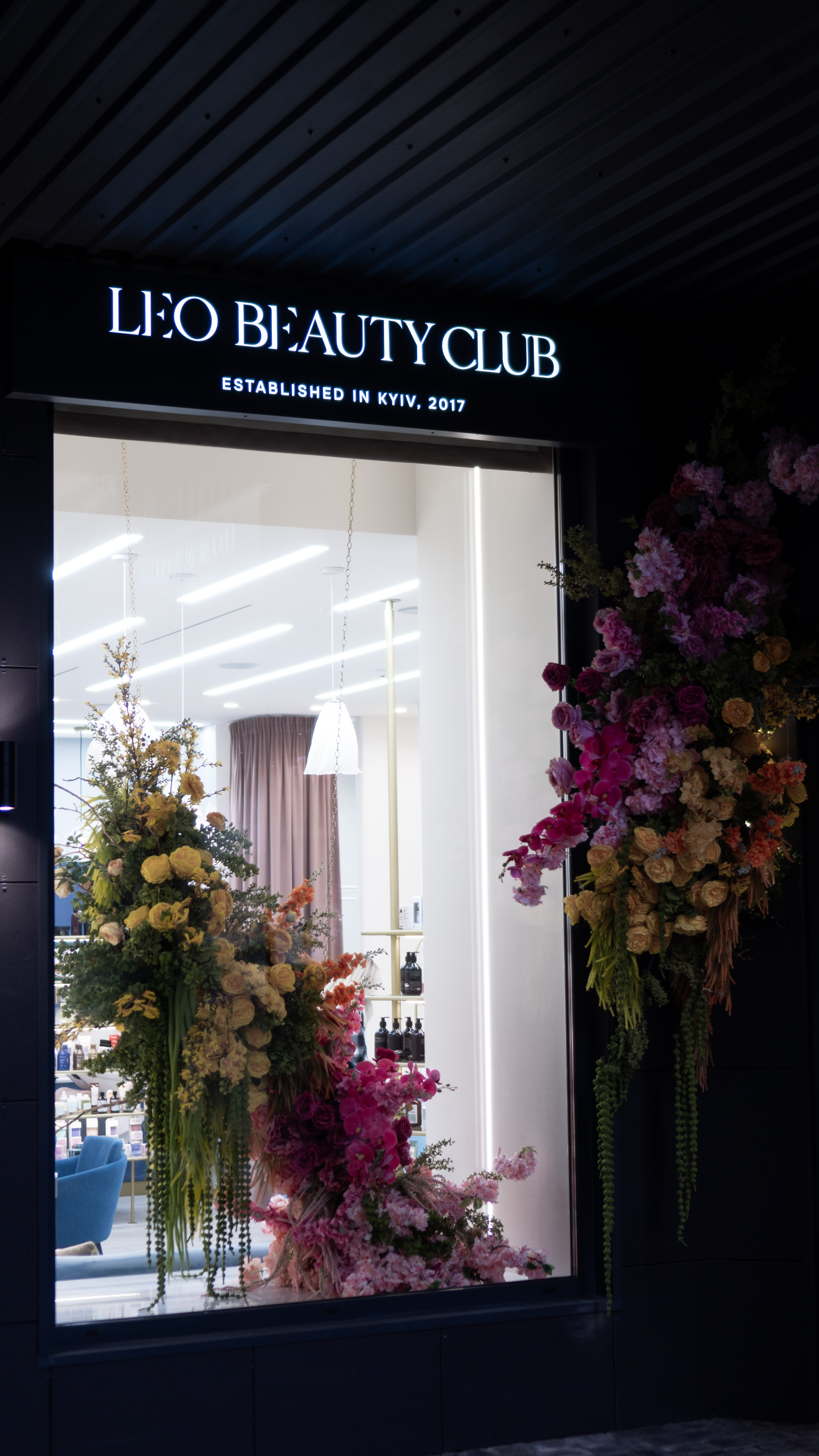 Leo Beauty Club Kyiv — salon entrance with floral installation and illuminated signage, established 2017